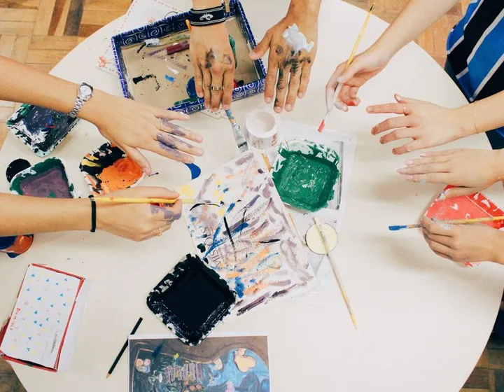 Hands working on a craft project at a group workshop table