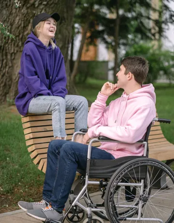 A support worker sitting and talking with a participant outdoors